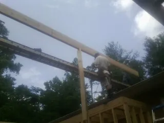 Carpenter setting a ridge beam over a new addition frame — Ice Dam Removal by Roofing Brothers in Haddon Heights