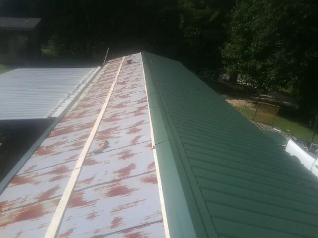 Old rusted panels beside newly installed green metal roofing — Wind Damage Roof Repair by Roofing Brothers in Haddon Heights