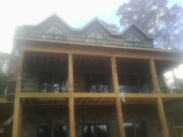 Dormers and porch framing on a large log home under construction — Roof Coating work by our crew in Haddon Heights
